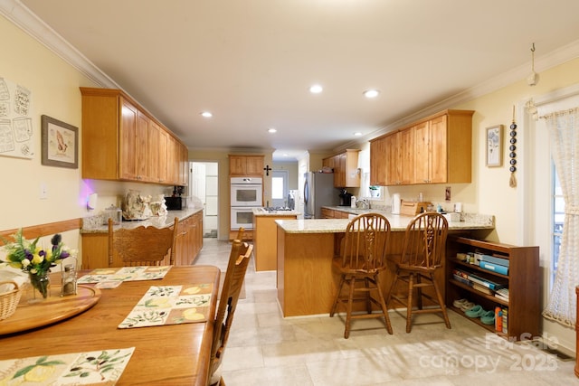 kitchen featuring ornamental molding, freestanding refrigerator, white double oven, and a peninsula