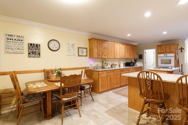 kitchen featuring recessed lighting, white appliances, a breakfast bar, light stone countertops, and crown molding