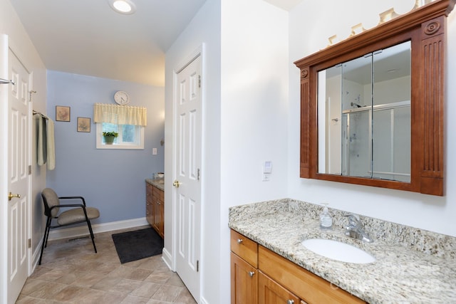 full bathroom with a shower stall, baseboards, and vanity