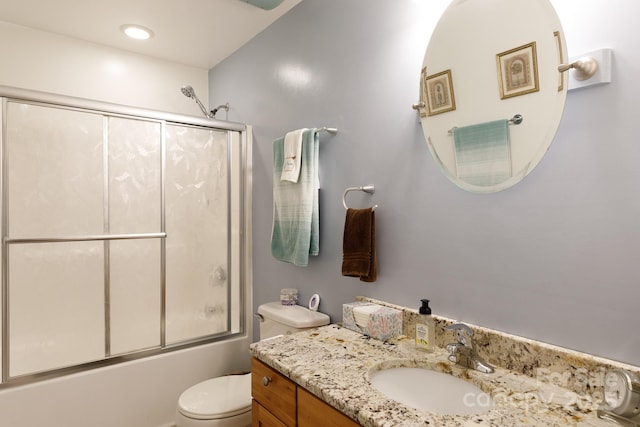 bathroom with toilet, combined bath / shower with glass door, and vanity