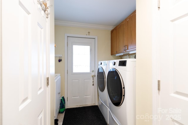 clothes washing area with cabinet space, washer and clothes dryer, and crown molding