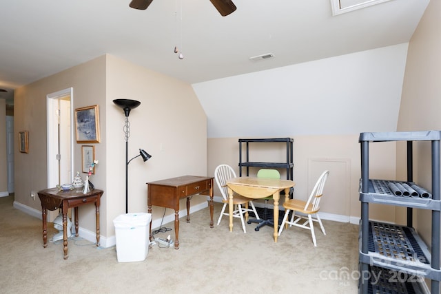 dining room featuring light carpet, ceiling fan, visible vents, and lofted ceiling