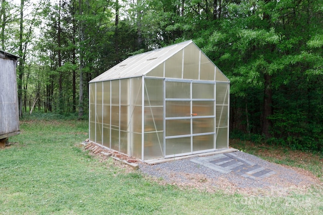 view of greenhouse with a yard