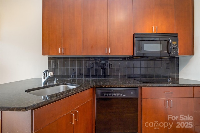 kitchen with dark stone countertops, backsplash, black appliances, and a sink