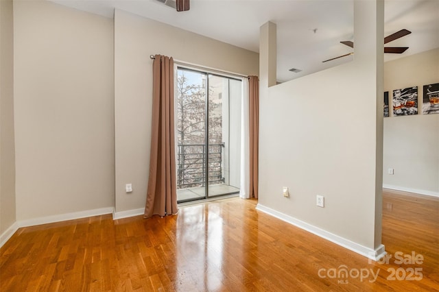 spare room with visible vents, a ceiling fan, baseboards, and light wood finished floors