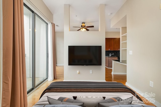 living room with a ceiling fan, a healthy amount of sunlight, light wood-type flooring, and baseboards