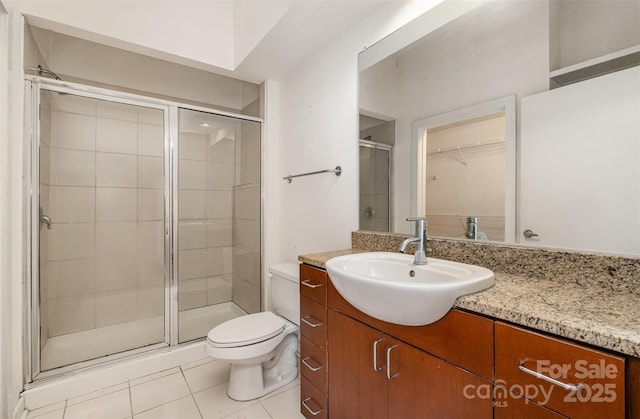 full bathroom featuring tile patterned flooring, a shower stall, toilet, and vanity