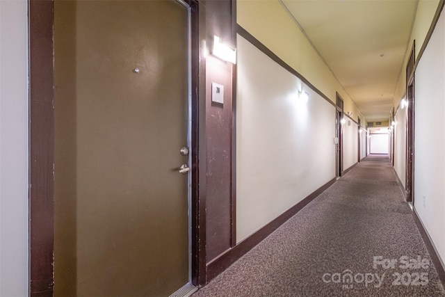 corridor with carpet flooring and baseboards