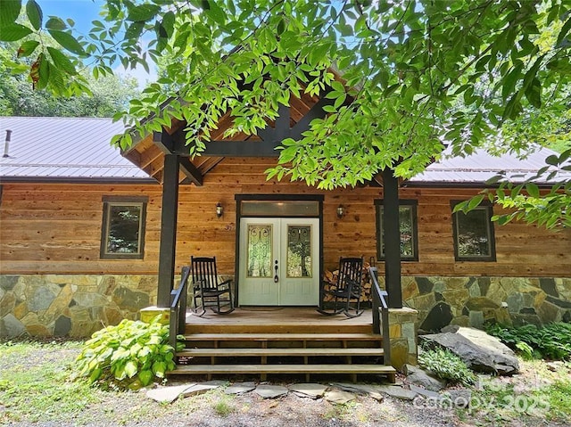 rear view of house with french doors, covered porch, and metal roof