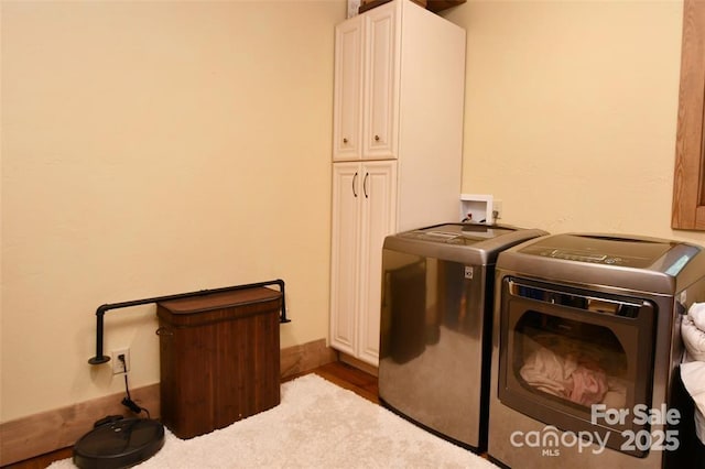 washroom with cabinet space and separate washer and dryer