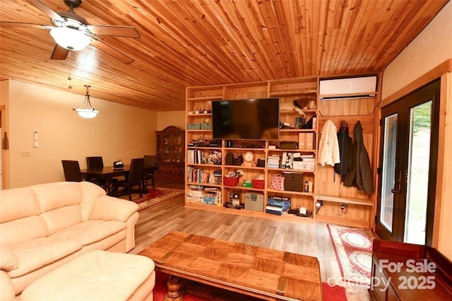 living room with a ceiling fan, wooden ceiling, a wall mounted air conditioner, and wood finished floors