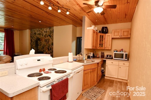 kitchen with light countertops, wood ceiling, a sink, white appliances, and a peninsula