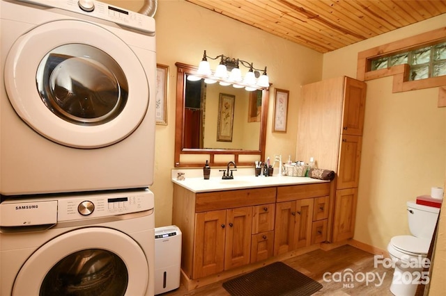 full bathroom featuring toilet, wood ceiling, wood finished floors, stacked washer / drying machine, and vanity