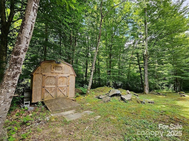 view of shed featuring a view of trees