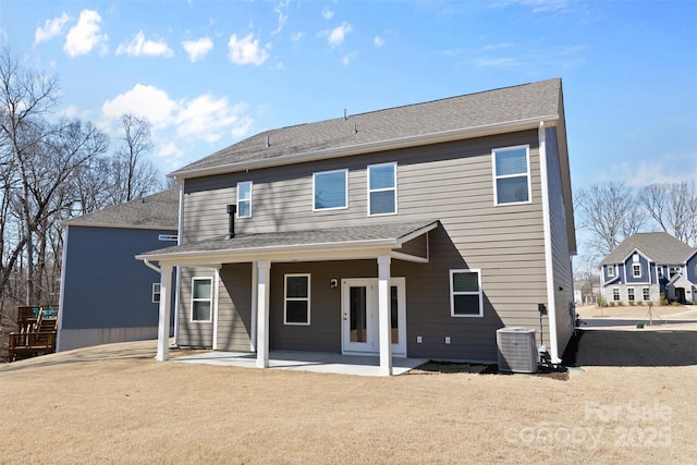 back of property with a patio area, cooling unit, and roof with shingles