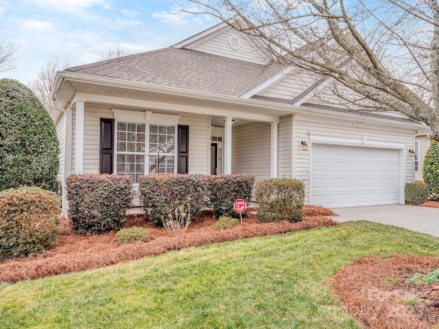 traditional-style house featuring a garage, a front yard, a shingled roof, and driveway