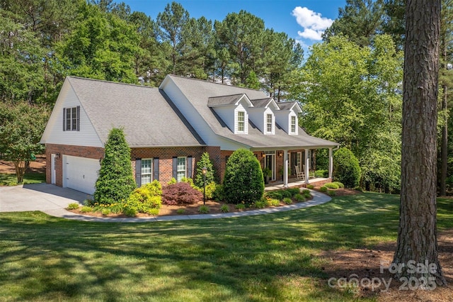 new england style home featuring brick siding, a porch, concrete driveway, a garage, and a front lawn