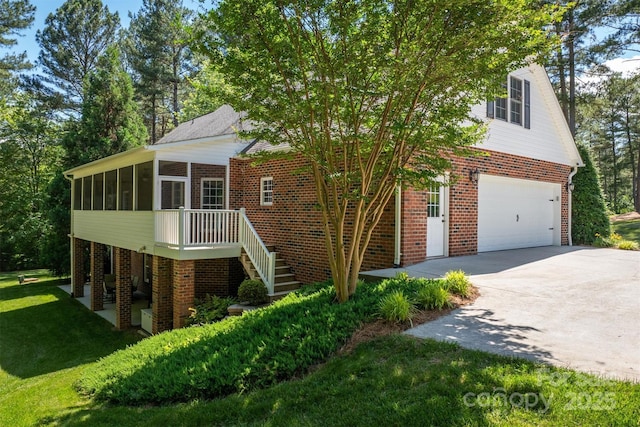 view of front of property with a sunroom, stairway, concrete driveway, and brick siding