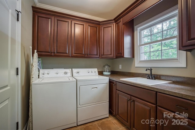 laundry room featuring cabinet space, light tile patterned floors, washer and clothes dryer, and a sink