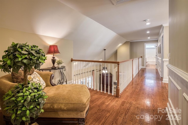 corridor featuring lofted ceiling, ornamental molding, wood finished floors, and recessed lighting