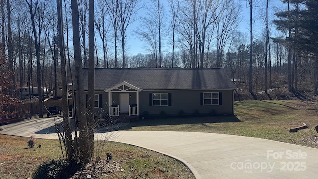 view of front of house with roof with shingles and a front yard