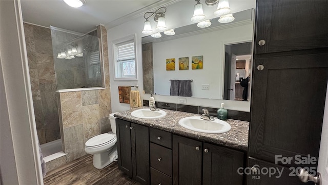 bathroom with a walk in shower, a sink, toilet, and crown molding