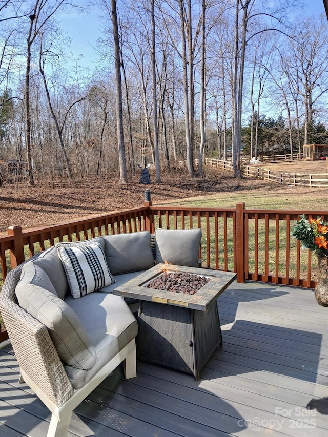 wooden terrace with an outdoor living space with a fire pit