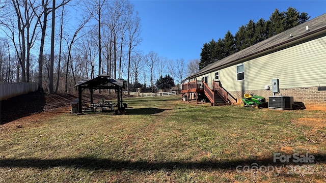 view of yard featuring stairs, central AC unit, fence, and a gazebo