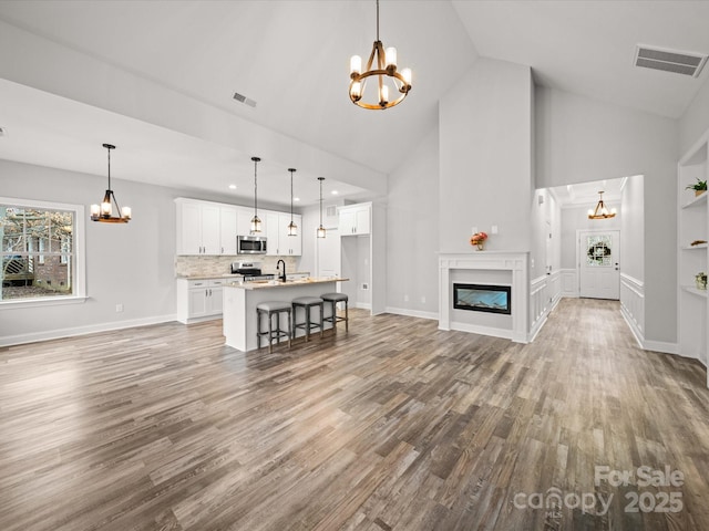 unfurnished living room with a notable chandelier and visible vents