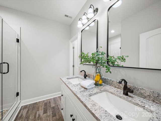 bathroom featuring a sink, wood finished floors, and a shower stall