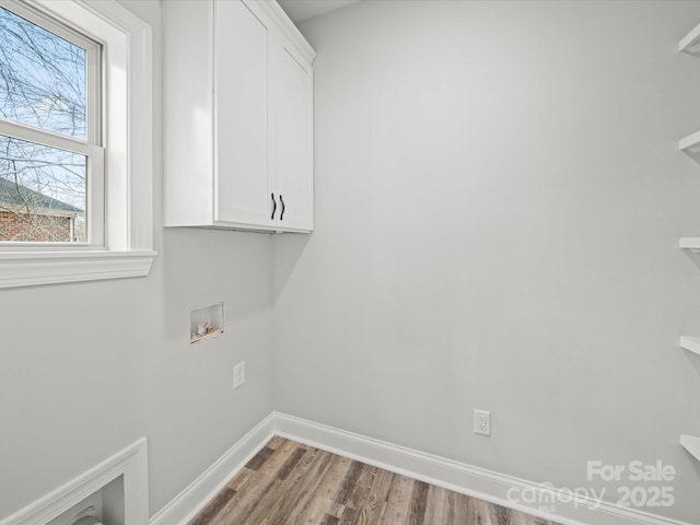 laundry area with cabinet space, wood finished floors, baseboards, and washer hookup