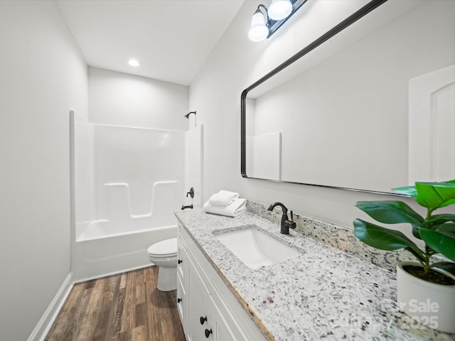 bathroom featuring toilet, wood finished floors, recessed lighting, shower / bath combination, and vanity