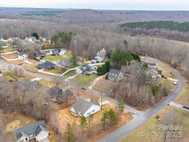 bird's eye view featuring a residential view and a wooded view