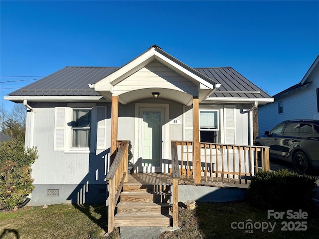 bungalow-style house featuring metal roof, a porch, and crawl space