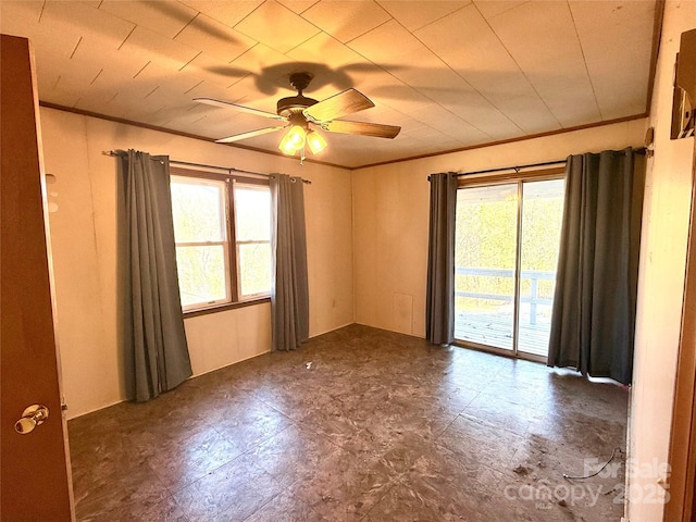 empty room with ceiling fan, crown molding, and tile patterned floors