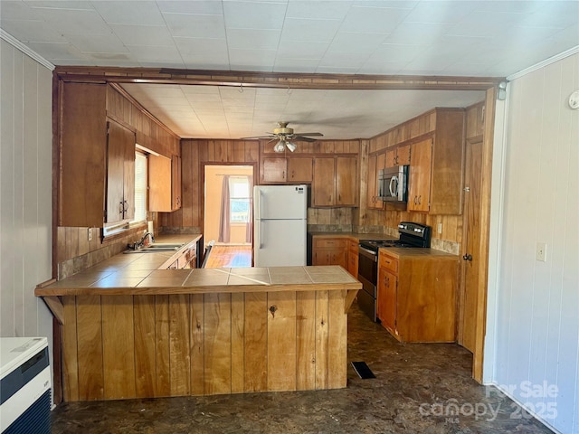 kitchen with tile counters, freestanding refrigerator, electric stove, and stainless steel microwave