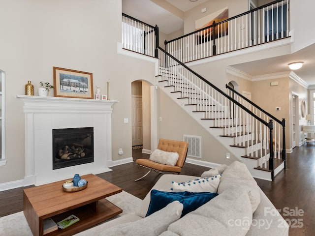 living area featuring stairway, wood finished floors, visible vents, and baseboards