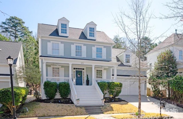 view of front of property featuring a porch, concrete driveway, stairs, and a garage