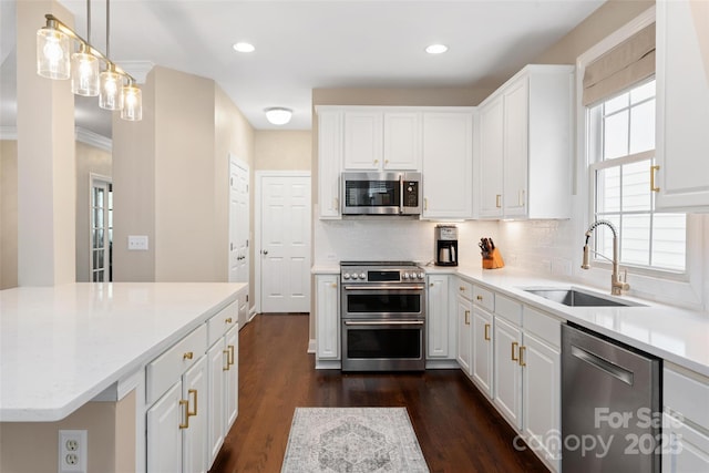 kitchen featuring white cabinets, backsplash, stainless steel appliances, and a sink