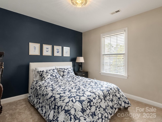 carpeted bedroom featuring baseboards and visible vents
