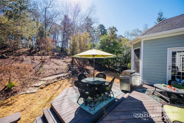 wooden deck featuring outdoor dining area and area for grilling