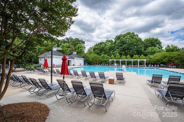 pool with a patio and fence