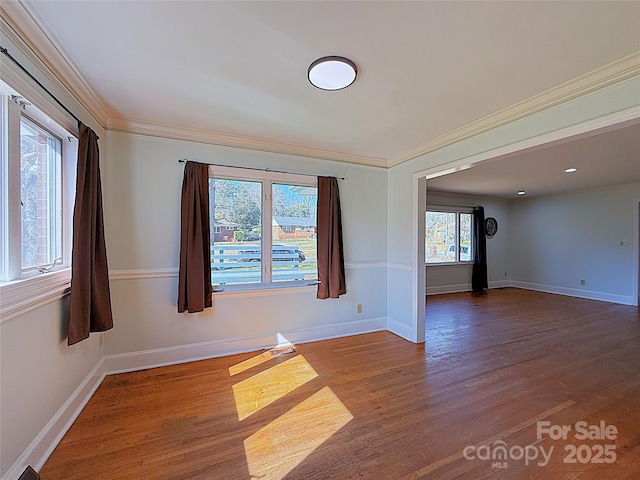 unfurnished room with crown molding, baseboards, and wood finished floors