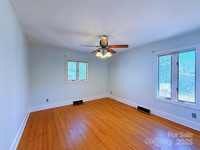 spare room featuring visible vents, ceiling fan, light wood-style flooring, and baseboards