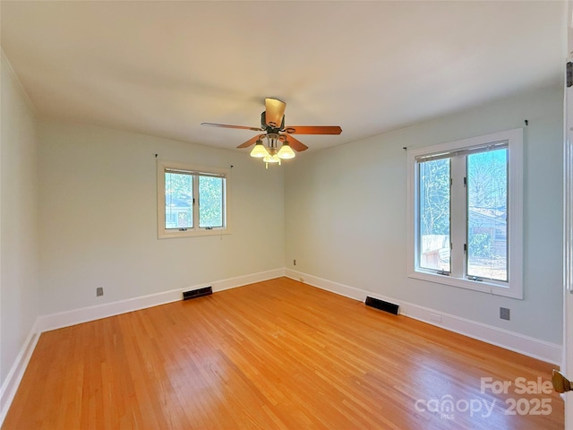 spare room with visible vents, ceiling fan, light wood-style flooring, and baseboards