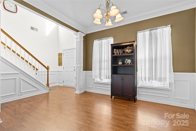 foyer featuring stairs, a healthy amount of sunlight, visible vents, and ornate columns