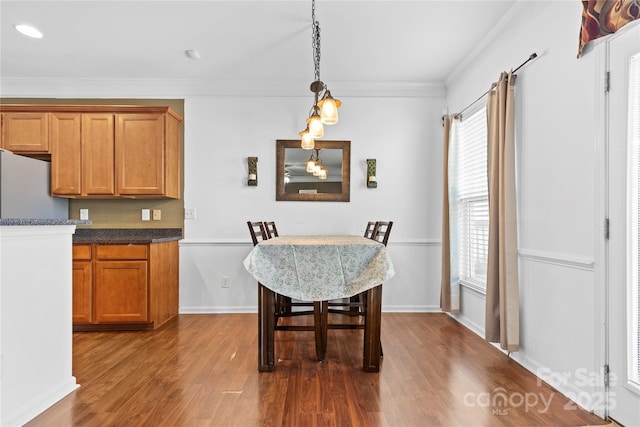 dining room with baseboards, dark wood finished floors, and crown molding