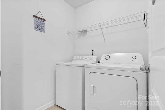 laundry room featuring laundry area, washing machine and dryer, and baseboards