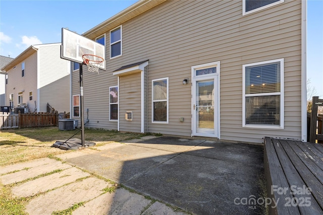 rear view of property featuring central AC unit, a patio area, and fence