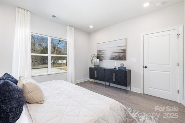 bedroom with visible vents, recessed lighting, baseboards, and wood finished floors